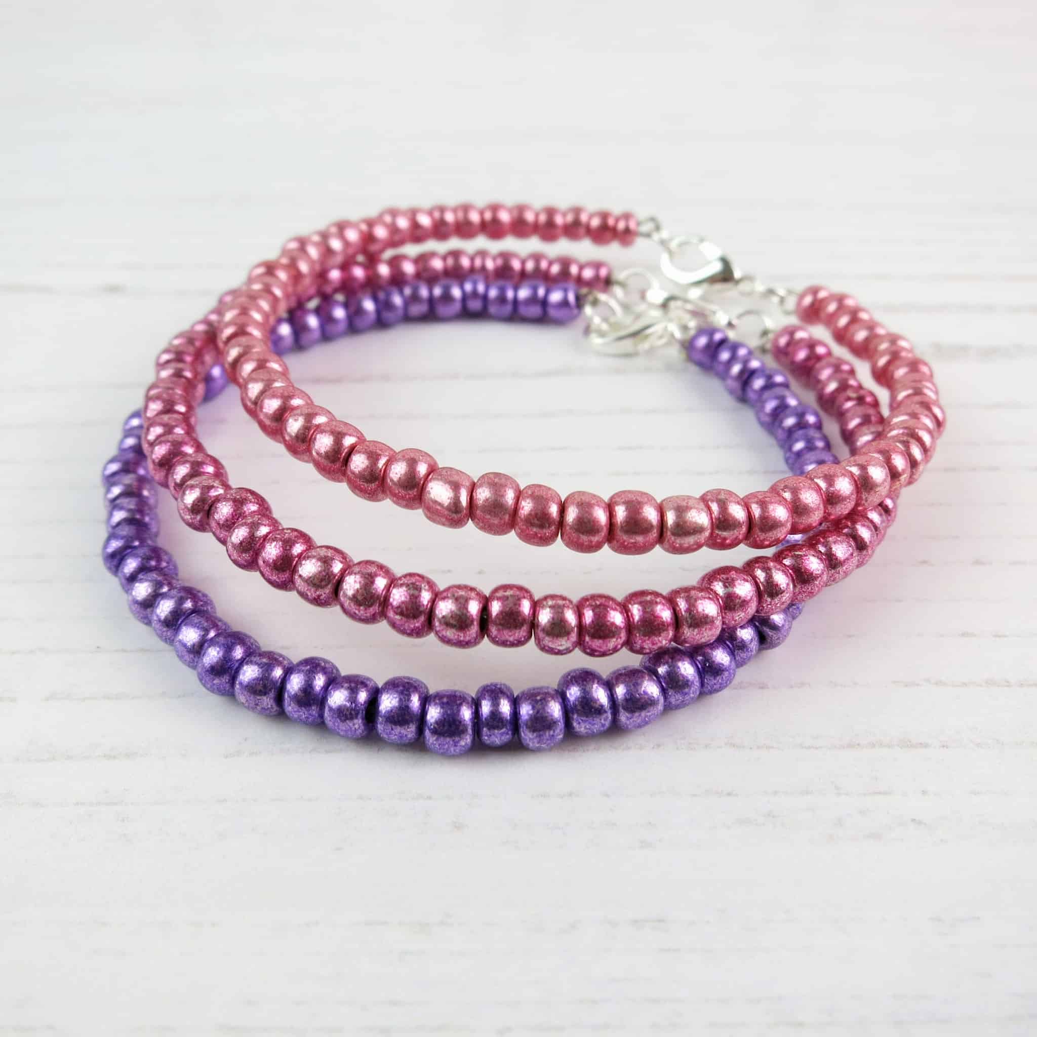 0D5F3C93-765D-40C9-8908-BD36495ECDEB A choice of purple, dark pink or pink metallic glass rocaille beads on a memory wire bracelet with a silver plated lobster catch.